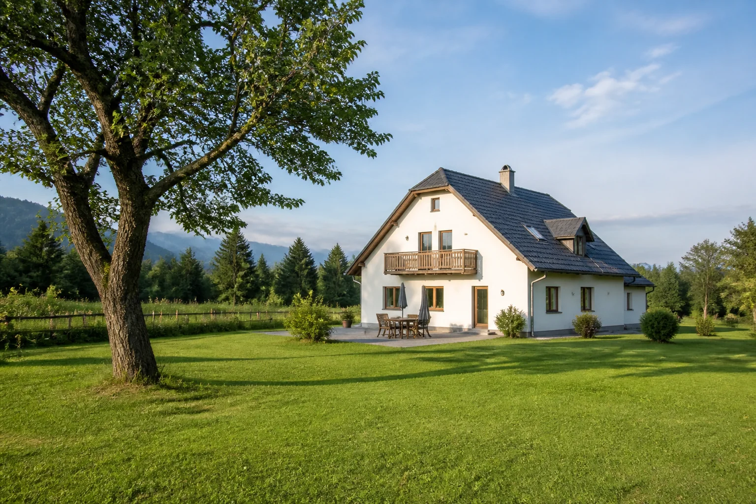 Österreichisches Wohnhaus an einer ruhigen Wiese mit altem Baum